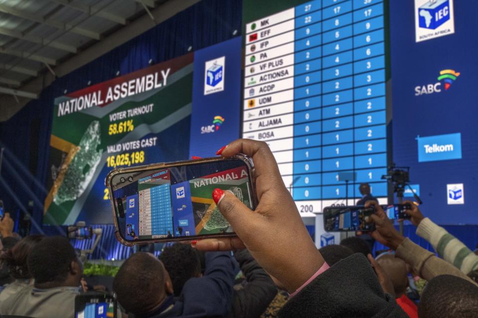 Guests and delegates use their phone at the formal announcement Sunday, June 2, 2024 of the results in South Africa's general elections at the National Results Operations Center in Johannesburg, South Africa. Humbled by a stinging election result, South Africa's African National Congress was talking to everyone in an effort to form a stable coalition government for Africa's most advanced economy after it lost its 30-year majority. (AP Photo/Jerome Delay)