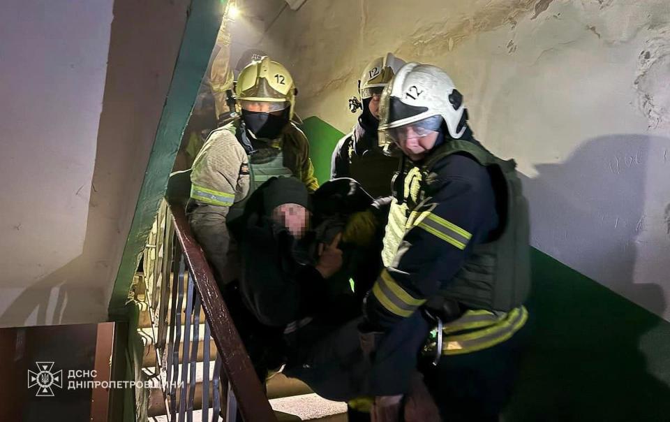 Ukrainian firefighters rescue a civilian from a building in Kryvyi Rih after a Russian missile strike