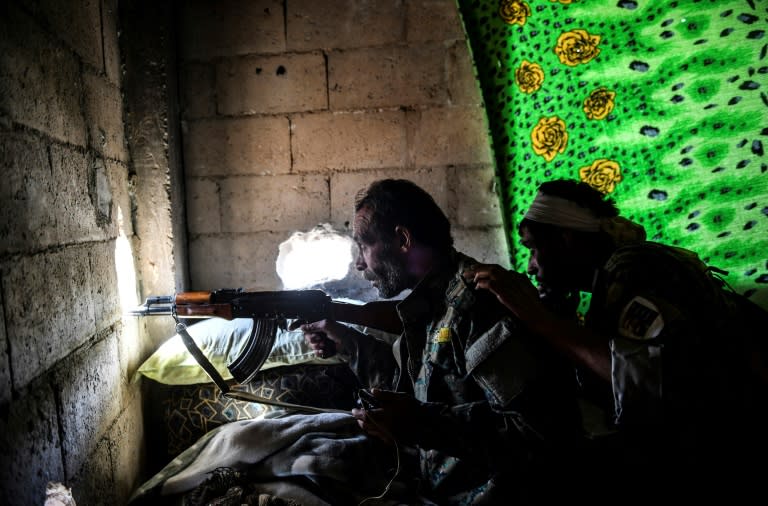 Members of the Syrian Democratic Forces (SDF) take a position inside a building on the eastern frontline of Raqa on October 5, 2017