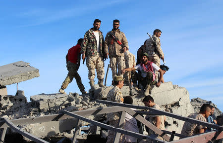 Fighters of Libyan forces allied with the U.N.-backed government gather atop the ruins of a house as they are close to securing last Islamic State holdouts in Sirte, Libya December 5, 2016. REUTERS/Ayman Sahely