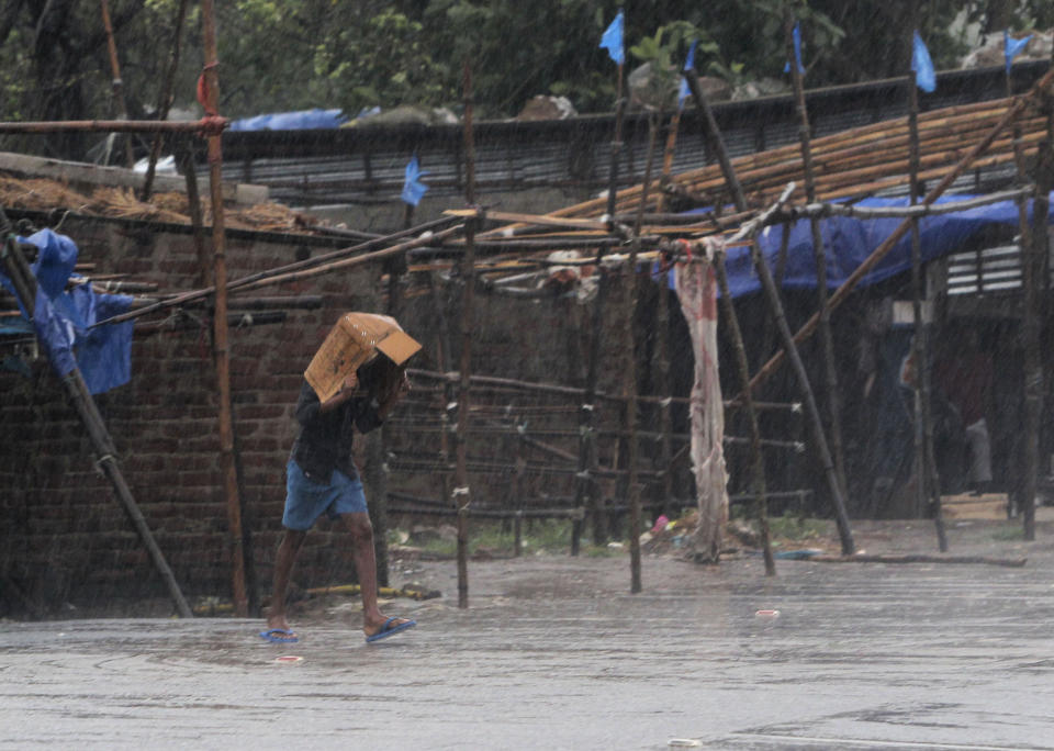 A man covers him head with a box and walks in the rain ahead of Cyclone Amphan landfall, at Bhadrak district, in the eastern Indian state of Orissa, Wednesday, May 20, 2020. A strong cyclone blew heavy rains and strong winds into coastal India and Bangladesh on Wednesday after more than 2.6 million people were moved to shelters in a frantic evacuation made more challenging by coronavirus. (AP Photo)