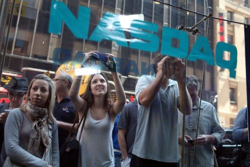 People look into the window of the Nasdaq stock market moments before Facebook shares went public on May 18. A lawsuit against the Nasdaq exchange said its massive technical problems on the first day of Facebook trade on Friday also resulted in losses to investors