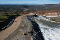 <p>Fotografía del 12 de febrero de 2017, cedida por el Departamento de Recursos Hídricos de California, muestra la erosión a una carretera provocada por la salida de agua del vertedero auxiliar de la presa de Oroville en el Lago Oroville, California (EE. UU.). Las autoridades ordenaron hoy, lunes 13 de febrero de 2017, las evacuaciones obligatorias de comunidades debajo de la presa de Oroville, donde se encontró un agujero en el vertedero de emergencia, amenazando una posible brecha e inundación de las áreas bajas debajo de la presa. Alrededor de 170.000 personas fueron evacuadas. EFE / Kelly M. Crecer </p>