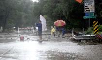 A man takes photos of the damage from heavy rains in Boulder, Colorado September 13, 2013. (REUTERS/Mark Leffingwell)