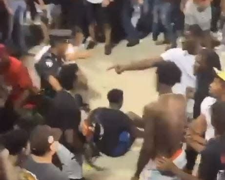 Mike Peake, right, in white shirt, can be seen pointing following a brawl Oct. 15, 2022, on the concourse of Aggie Memorial Stadium. This screenshot is from a video posted to Twitter from user @tioneomo.