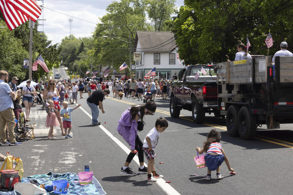 Children collect candy while watching a parade on June 9, 2024, in Waubeka, Wis. Old Glory is venerated annually in Waubeka, the small town that lays claim to the first Flag Day. (AP Photo/Teresa Crawford)