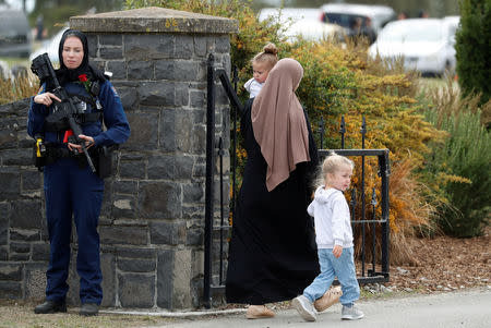 A policewoman is seen as people attend the burial ceremony of a victim of the mosque attacks, at the Memorial Park Cemetery in Christchurch, New Zealand March 21, 2019. REUTERS/Jorge Silva