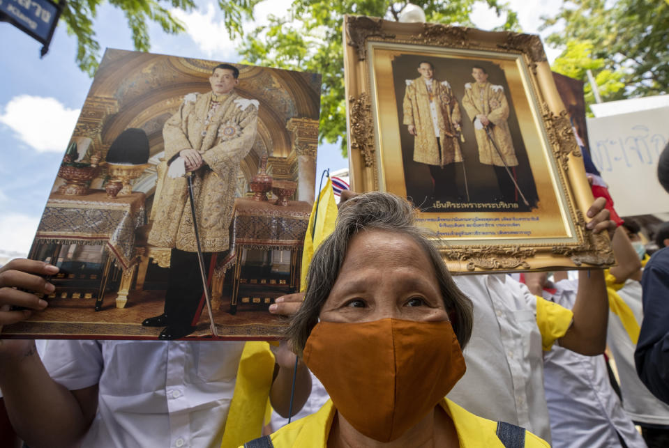 Supporters of Thailand's monarchy hold portraits of King Maha Vajiralongkorn and portraits of the late King Bhumibol Adulyadej as they gather to show their concern over the country's pro-democracy movement, which they feel besmirches the royal institution in Bangkok, Thailand, Thursday, July 30, 2020. The demonstration was held at Democracy Monument, a traditional venue for protests of all political stripes that in recent weeks has hosted several larger pro-democracy, anti-government protests organized by students. (AP Photo/Sakchai Lalit)