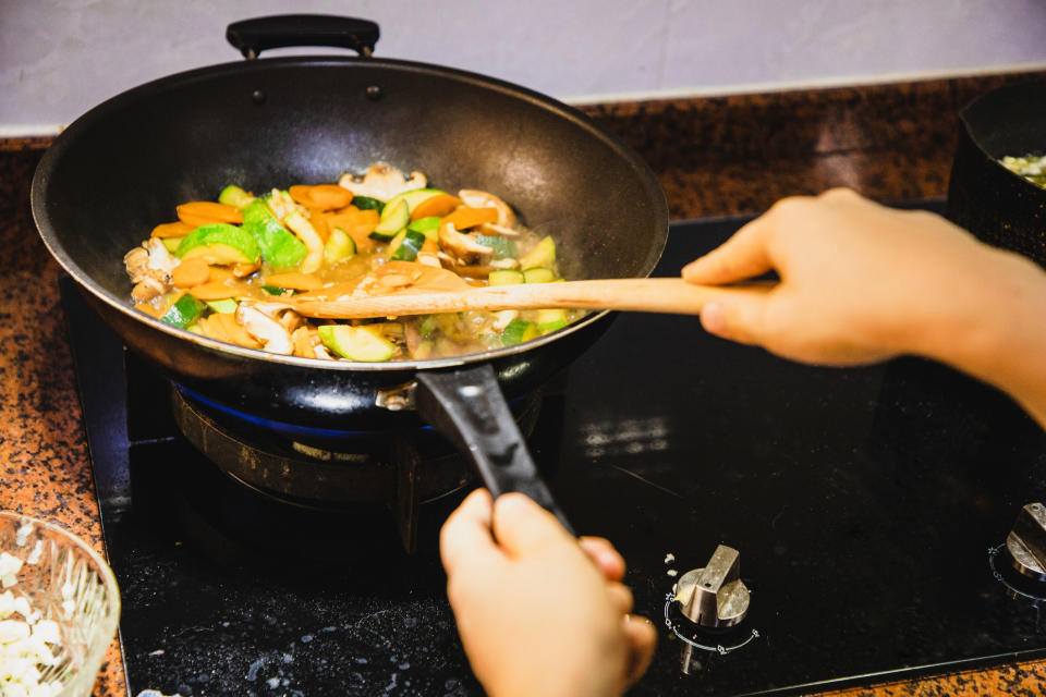 A person making a vegetable stir-fry.