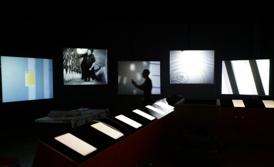 In this Tuesday, Oct. 1, 2013 photo, a worker, center, photographs the exhibits of the Detroit Institute of Arts newest exhibition, “Watch Me Move: The Animation Show,” which organizers are calling the “most extensive animation show ever mounted.” The exhibit features both iconic pieces as well as a host of lesser-known works that span the past 100-plus years. Visitors will be able to peruse more than 100 animated film segments _ nearly 12 hours’ worth of footage in all. (AP Photo/Carlos Osorio)