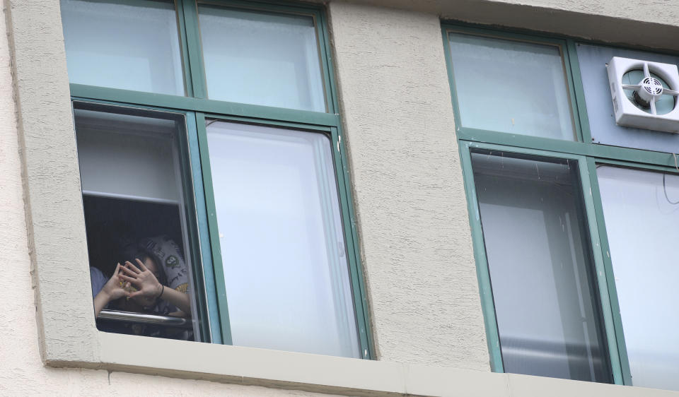 A student in a classroom covers her face with her hands at Songchon High School in Daejeon, South Korea, Friday, Aug. 4, 2023. South Korean police are chasing the suspect in a stabbing attack at the high school in the central city of Daejeon, a day after another stabbing incident at a shopping mall in the city of Seongnam, south of Seoul, leaving multiple people wounded. (Kang Soo-hwan/Yonhap via AP)