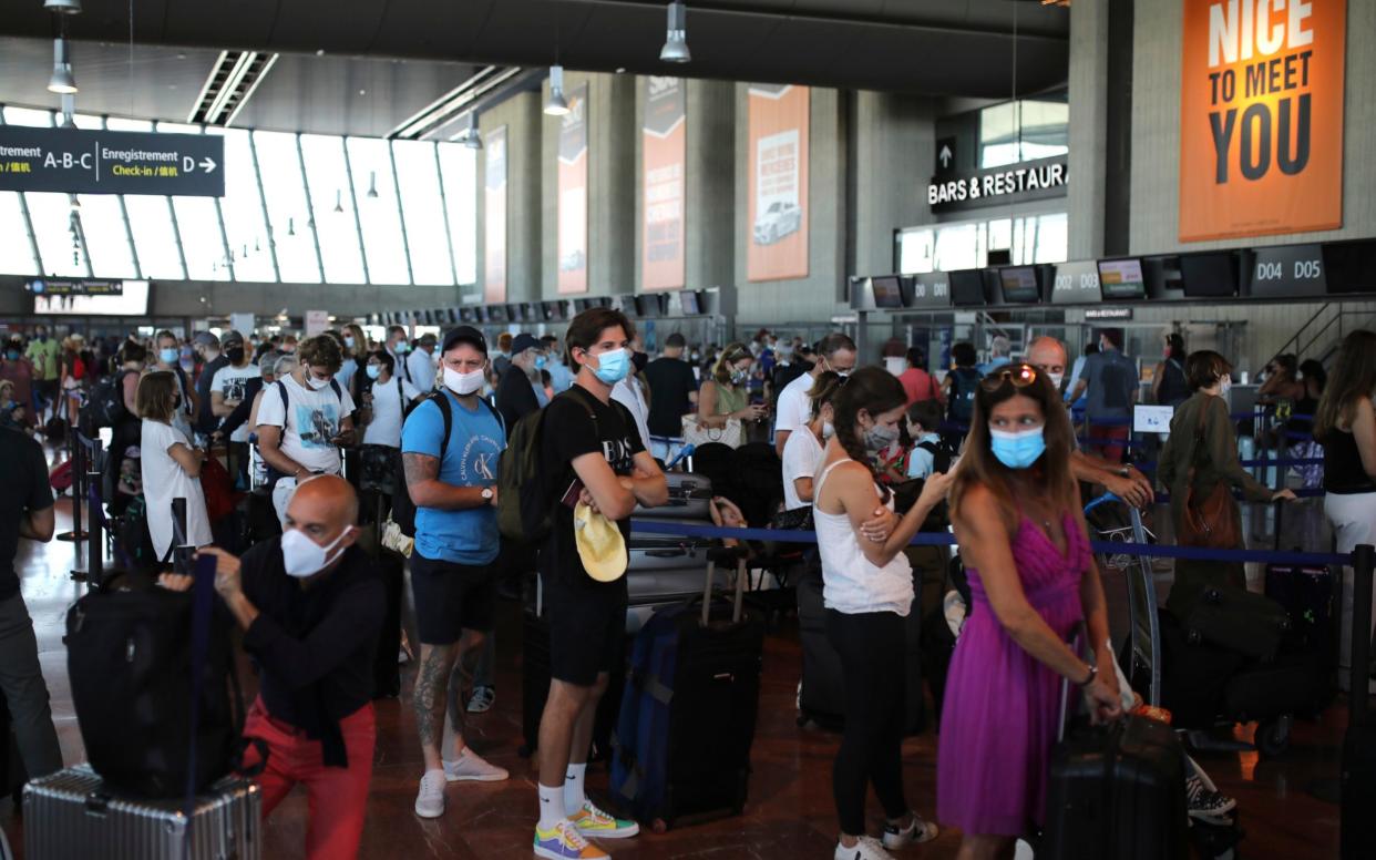 People queue to check-in for a British Airways flight from Nice to Heathrow - Daniel Cole/AP