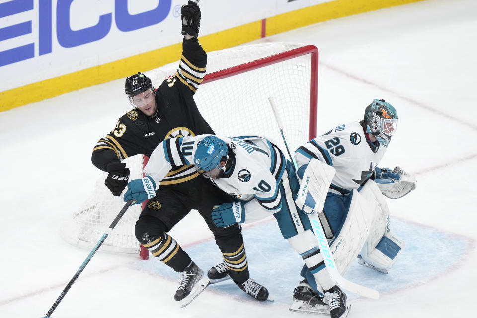 Boston Bruins center Charlie Coyle and San Jose Sharks left wing Anthony Duclair (10) collide as goaltender Mackenzie Blackwood defends the net in the second period of an NHL hockey game, Thursday, Nov. 30, 2023, in Boston. (AP Photo/Steven Senne)