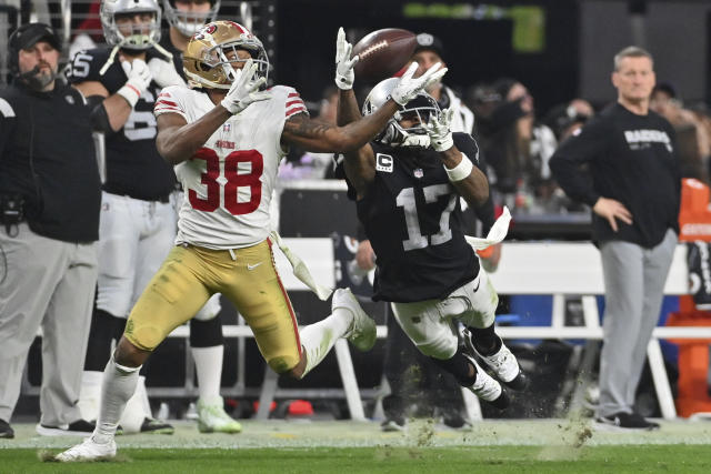 Las Vegas Raiders wide receiver Davante Adams (17) catches a pass while being defended by San Francisco 49ers cornerback Deommodore Lenoir (38) during the second half of an NFL football game between the San Francisco 49ers and Las Vegas Raiders, Sunday, Jan. 1, 2023, in Las Vegas. (AP Photo/David Becker)