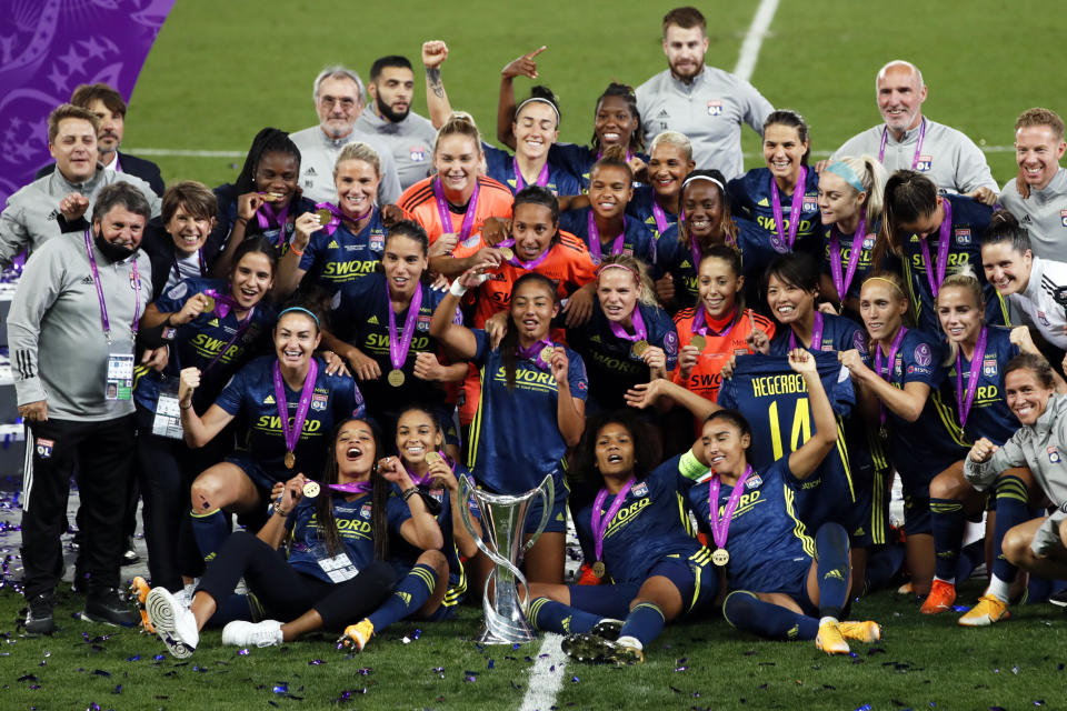 Lyon players pose with the trophy after winning the Women's Champions League final soccer match between Wolfsburg and Lyon at the Anoeta stadium in San Sebastian, Spain, Sunday, Aug. 30, 2020. Lyon won 3-1. (Clive Brunskill/Pool via AP)