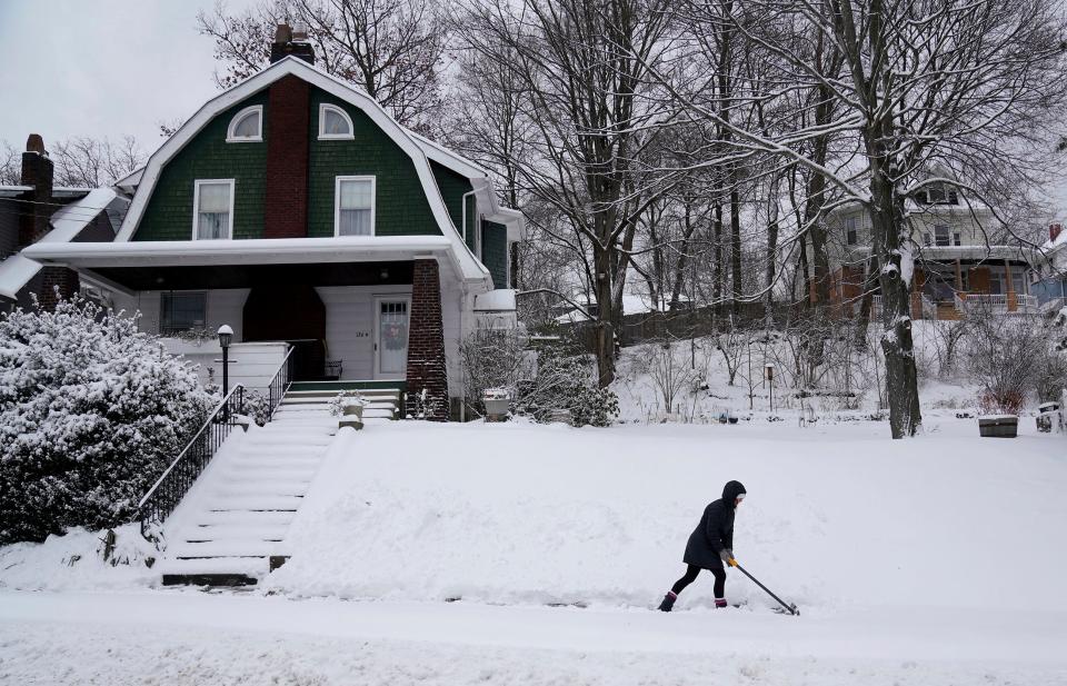 Emily Heller shovels the walkway in front of a neighbor's house on Center Avenue in Emsworth, Pa. on Monday, Jan. 17, 2022. A winter storm dumped several inches of snow on the Pittsburgh region overnight.