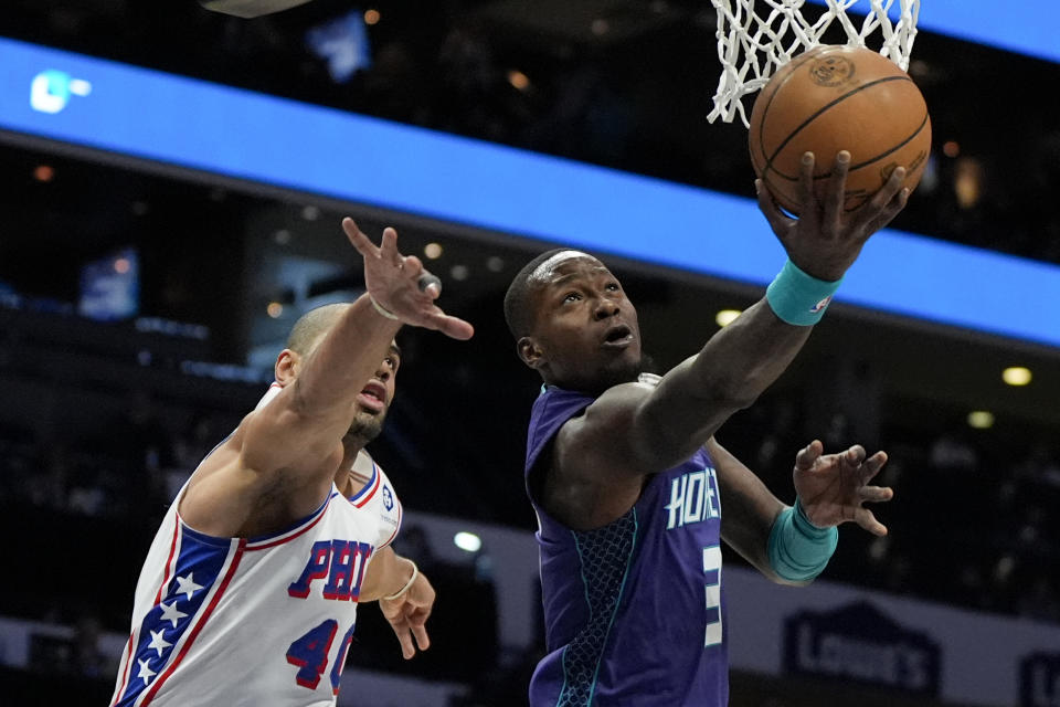 Charlotte Hornets guard Terry Rozier drives to the basket past Philadelphia 76ers forward Nicolas Batum during the first half of an NBA basketball game on Saturday, Jan. 20, 2024, in Charlotte, N.C. (AP Photo/Chris Carlson)