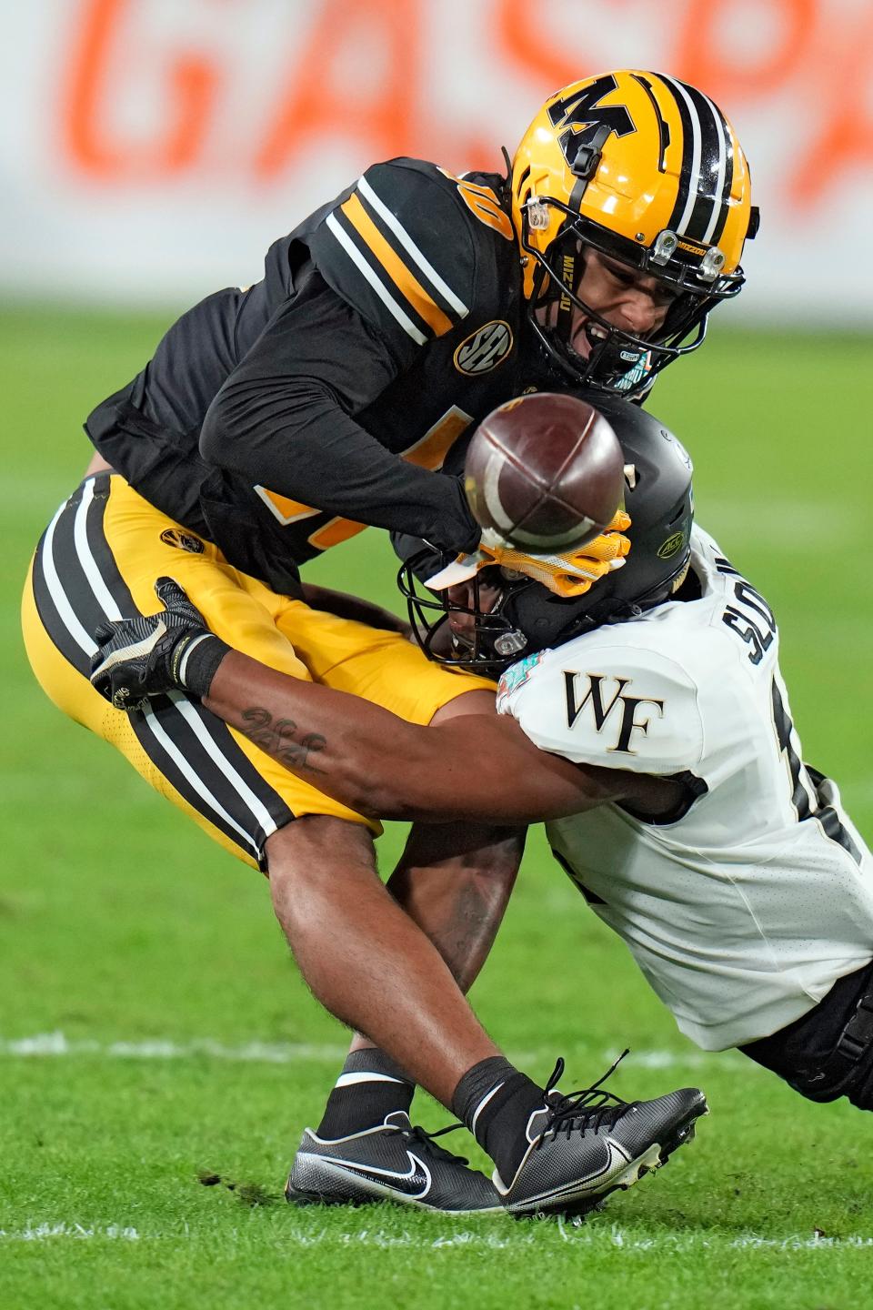 Missouri wide receiver Mekhi Miller (10) loses the ball after getting hit by Wake Forest defensive back Evan Slocum (14) during the first half of the Gasparilla Bowl NCAA college football game Friday, Dec. 23, 2022, in Tampa, Fla. The pass was ruled incomplete.