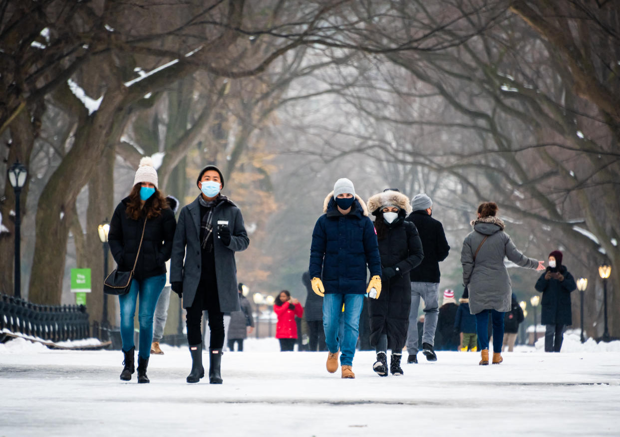 NEW YORK, NEW YORK - DECEMBER 20: People wear face masks at The Mall in Central Park on December 20, 2020 in New York City. The coronavirus pandemic has caused long-term repercussions throughout the tourism and entertainment industries, including temporary and permanent closures of historic and iconic venues, costing the city and businesses billions in revenue. (Photo by Noam Galai/Getty Images)