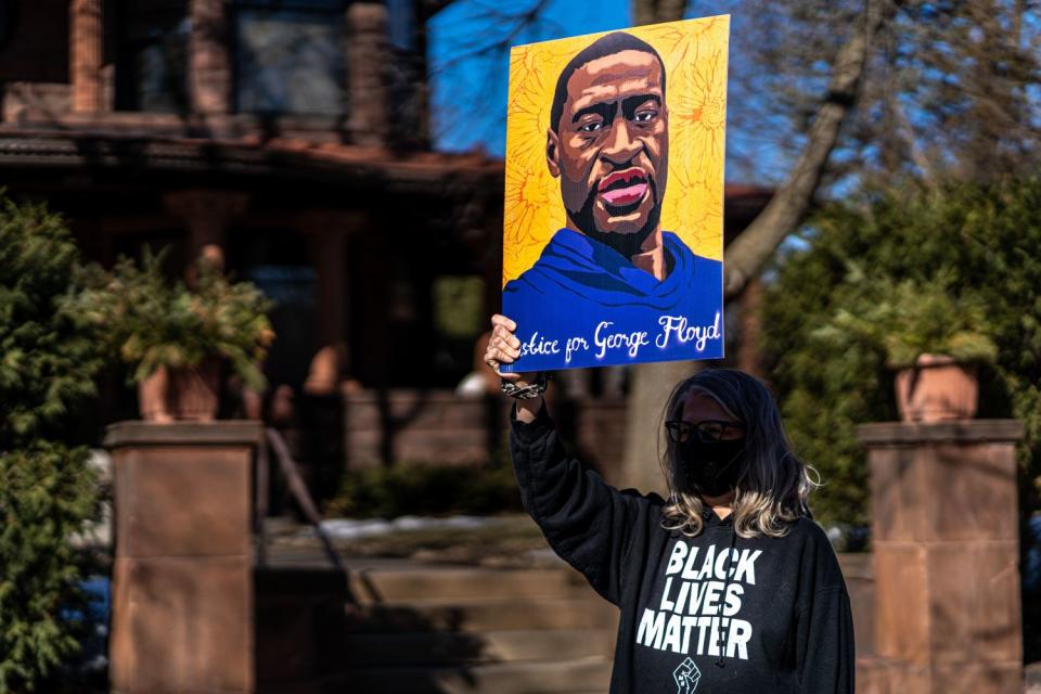 Kendra Waldeyer holds an image of George Floyd