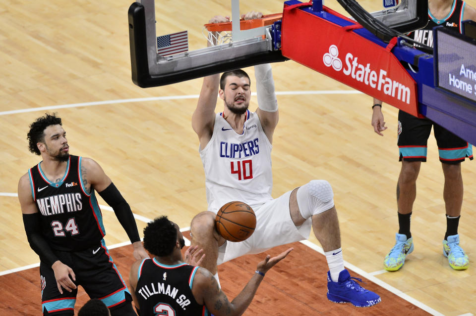 Los Angeles Clippers center Ivica Zubac (40) dunks the ball against Memphis Grizzlies center Xavier Tillman (2) as guard Dillon Brooks (24) looks on in the second half of an NBA basketball game Thursday, Feb. 25, 2021, in Memphis, Tenn. (AP Photo/Brandon Dill)