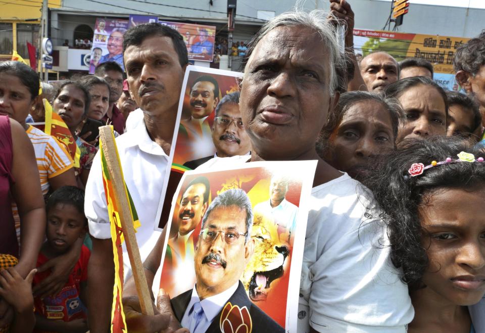 In this Aug 16, 2019, photo, supporters of former Sri Lankan Defense Secretary and opposition’s presidential candidate Nandasena Gotabaya Rajapaksa, carry his portrait, and await his arrival in Ambalanthota, Sri Lanka. Gotabaya is a feared former defense official accused of human rights abuses and crushing critics, but to many Sri Lankans, he is the leader most needed after last April’s Easter bomb attacks that killed more than 250 people. (AP Photo/Sajeewa Chinthaka)