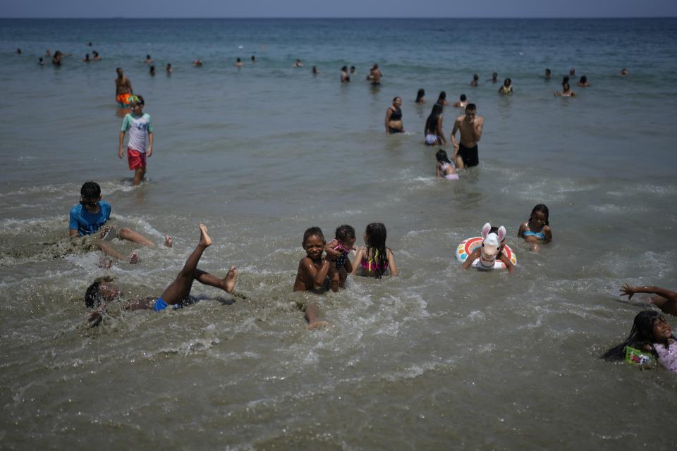 FILE - Children swim at the beach in La Guaira, Venezuela, Sept. 16, 2023. (AP Photo/Ariana Cubillos, File)