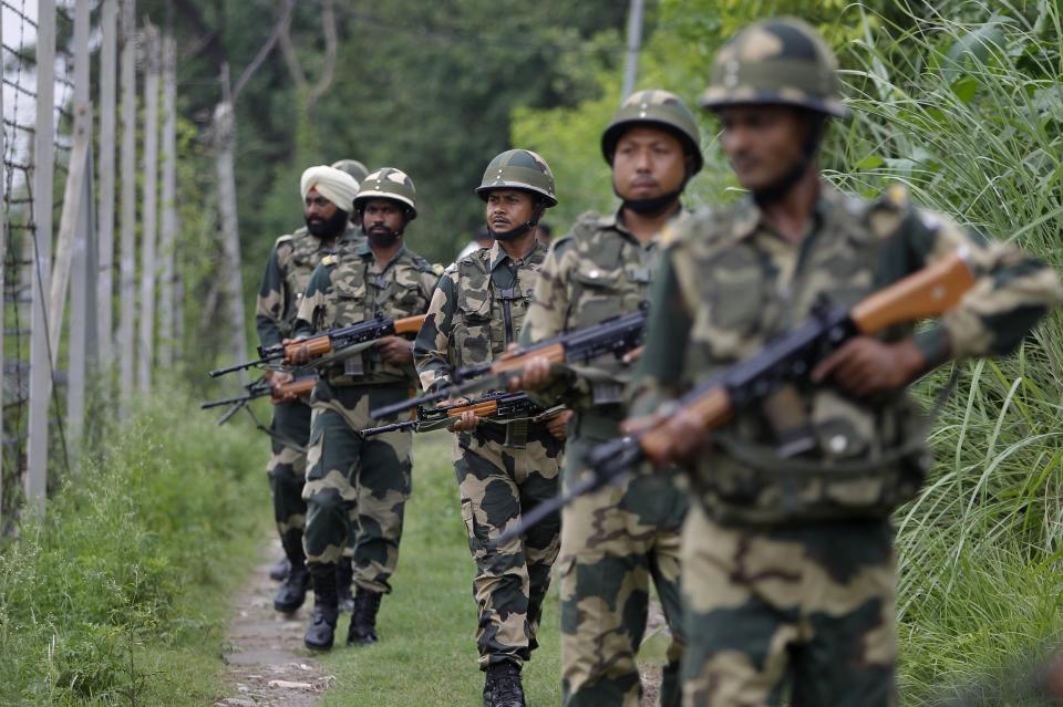 In this Tuesday, Aug. 13, 2019 file photo, India's Border Security Force (BSF) soldiers patrol near the India Pakistan border fencing at Garkhal in Akhnoor, about 35 kilometers (22 miles) west of Jammu, India. Pakistan's prime minister assured Kashmiri people living in the Indian-administered part of the divided region that he supports them in their struggle for self-determination. In his statement Wednesday, Imran Khan condemned New Delhi's decision Aug. 5 to downgrade Kashmir's status, as he began celebrations marking Pakistan's independence day.(AP Photo/Channi Anand)