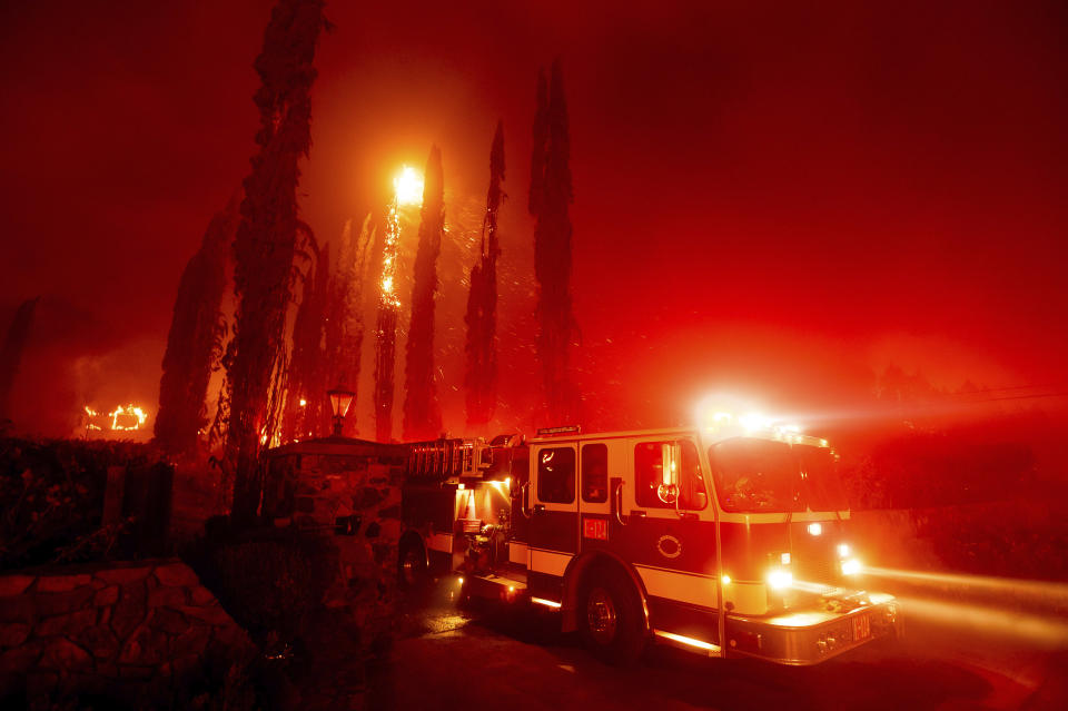 A fire engine leaves a burning property as the Glass Fire tears through St. Helena, Calif., on Sunday, Sept. 27, 2020. (AP Photo/Noah Berger)