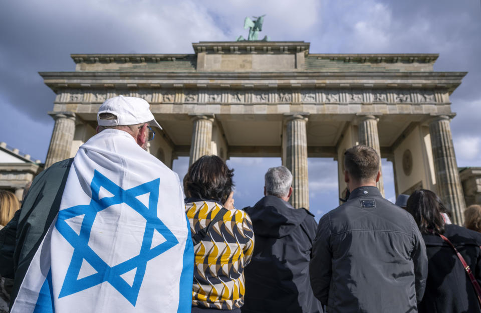People, one draped in an Israeli flag take part in a demonstration against antisemitism and to show solidarity with Israel, in front of the Brandenburg Gate, in Berlin, Germany, Sunday, Oct. 22, 2023. (Monika Skolimowska/dpa via AP)
