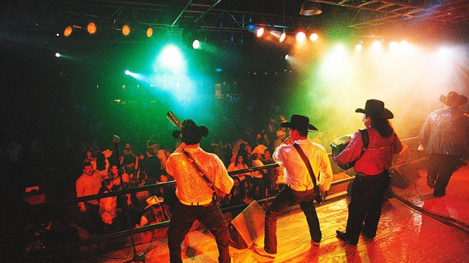 Un grupo de narcocorridos actuando sobre el escenario.