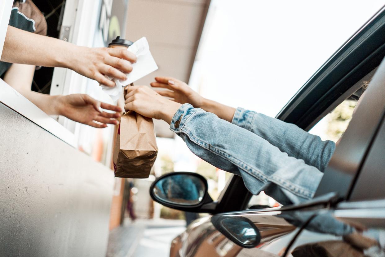 woman recieving a receipt and ordered food at drive through