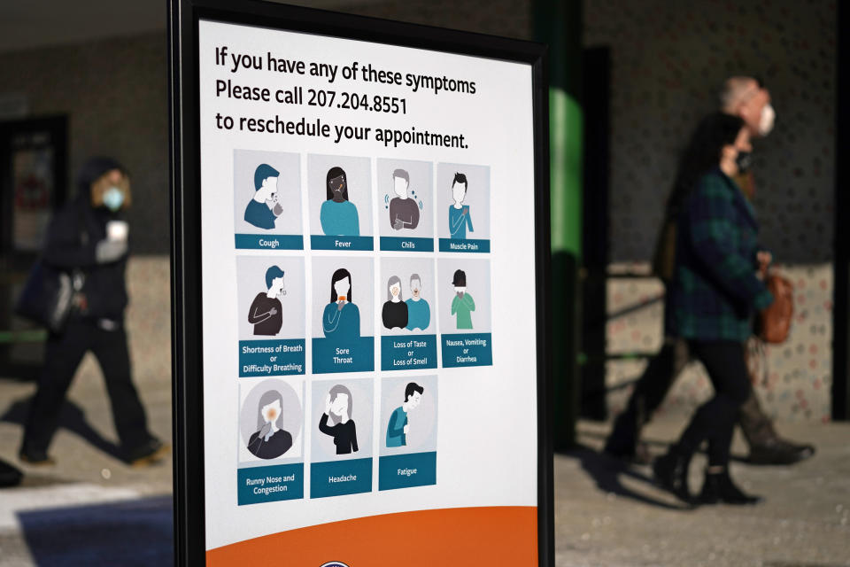 A sign lists symptoms that would require a rescheduled appointment at a COVID-19 mass vaccination site, Tuesday, March 2, 2021, at the Portland Expo in Portland, Maine. (AP Photo/Robert F. Bukaty)