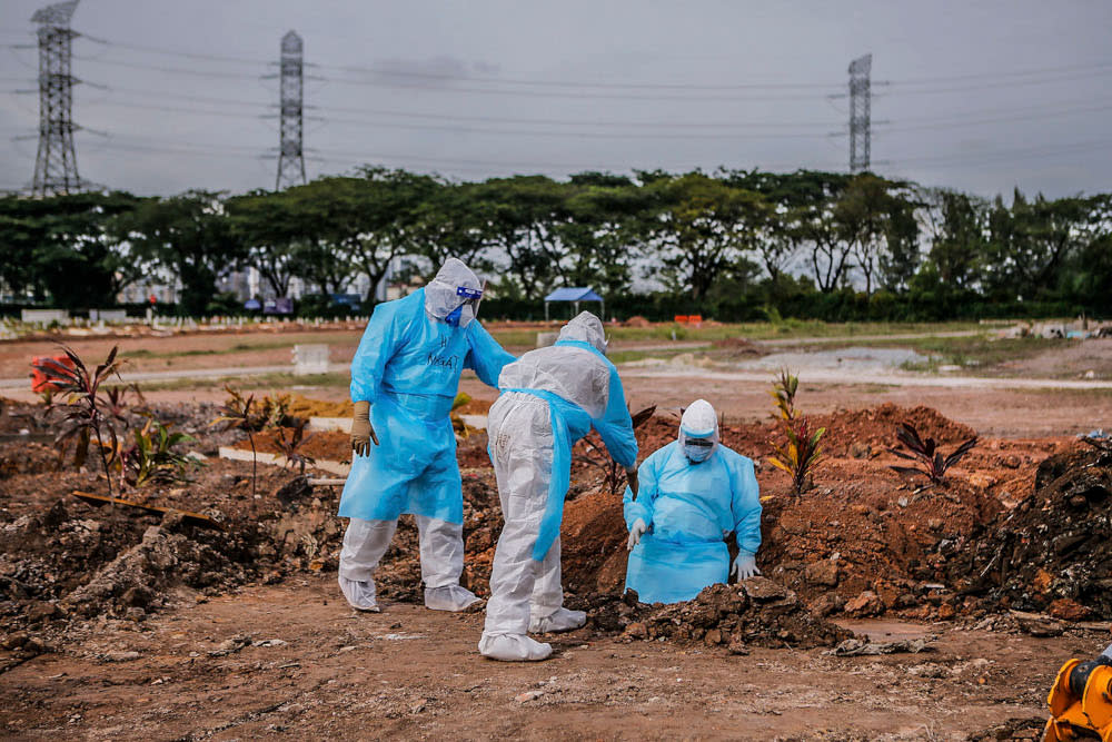 Health workers in personal protective equipment bury the body of a Covid-19 victim at the Muslim cemetery in Section 21, Shah Alam July 10, 2021. ― Picture by Hari Anggara