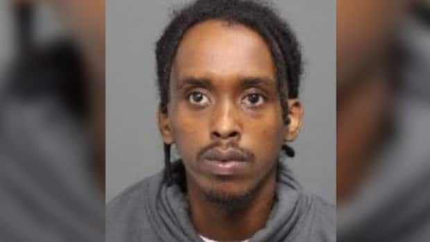 Haybe Farhan Aden, 26, is wanted in connection with a July 4 shooting in Lowertown that killed 20-year-old Tyson Ndongozi and injured an 18-year-old man. (Ottawa Police Service - image credit)