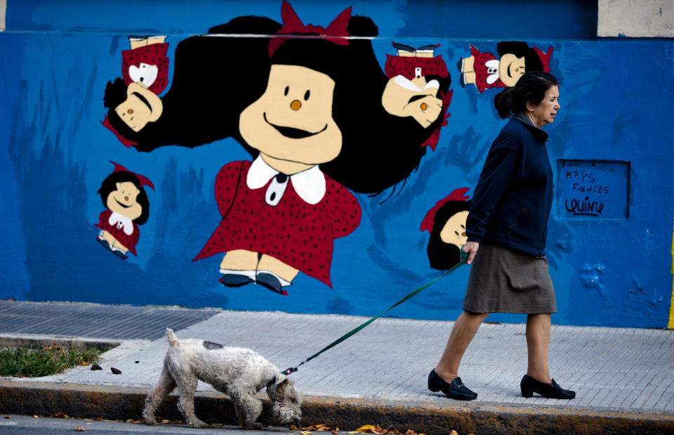 Una mujer pasea con su perro frente a un hospital infantil con un mural de Mafalda, el personaje principal de la tira cómica homónima del caricaturista argentino Joaquín Salvador Lavado “Quino” en Buenos Aires, Argentina, el miércoles 23 de abril de 2014. Quino inauguró la feria del libro de Buenos Aires 2014 el jueves 24 de abril. (Foto AP/Natacha Pisarenko)