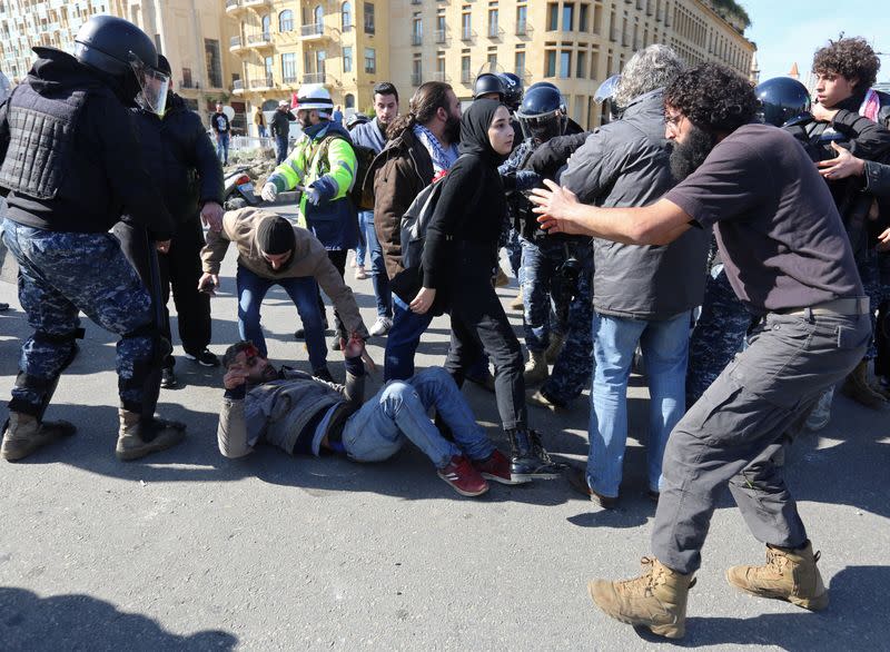 Injured protestor lies on the ground during a protest against the political elite in Beirut
