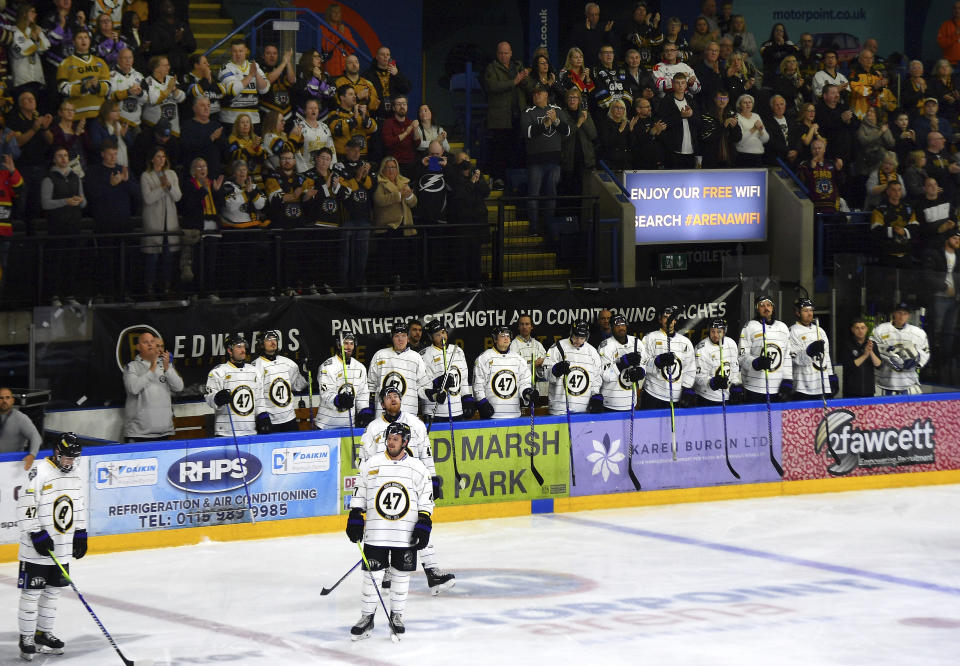 Players and fans stop the game and applaud in the 47th minute of the Ice Hockey Adam Johnson memorial game between Nottingham Panthers and Manchester Storm at the Motorpoint Arena, Nottingham, England, Saturday, Nov. 18, 2023. The memorial game is held three weeks after Johnson, 29, suffered a fatal cut to his neck during a game against Sheffield Steelers on Saturday, Oct. 28. (AP Photo/Rui Vieira)
