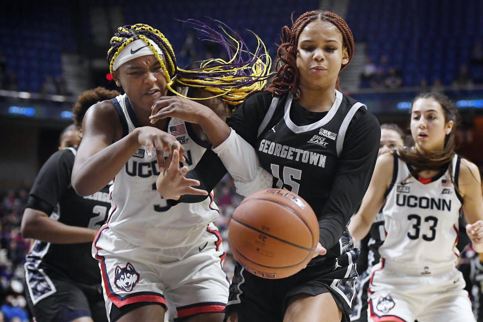 Connecticut's Aaliyah Edwards, left, and Georgetown's Brianna Scott, right, fight for the ball in the second half of an NCAA college basketball game in the Big East tournament quarterfinals at Mohegan Sun Arena, Saturday, March 5, 2022, in Uncasville, Conn. (AP Photo/Jessica Hill)