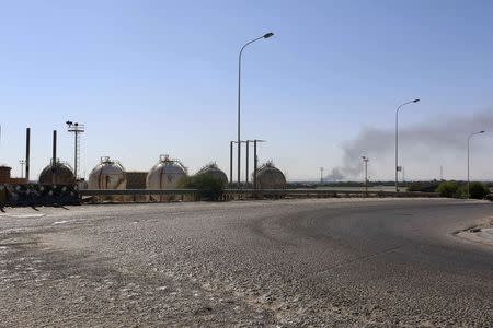 Smoke rises near oil tanks after heavy fighting between rival militias broke out near the airport in Tripoli July 23, 2014. REUTERS/Hani Amara