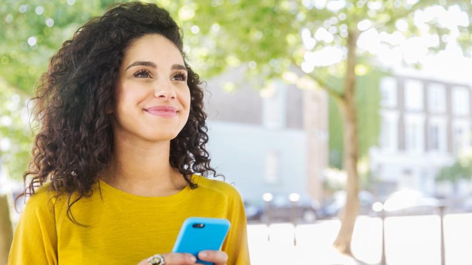 Mujer con celular mirando el horizonte