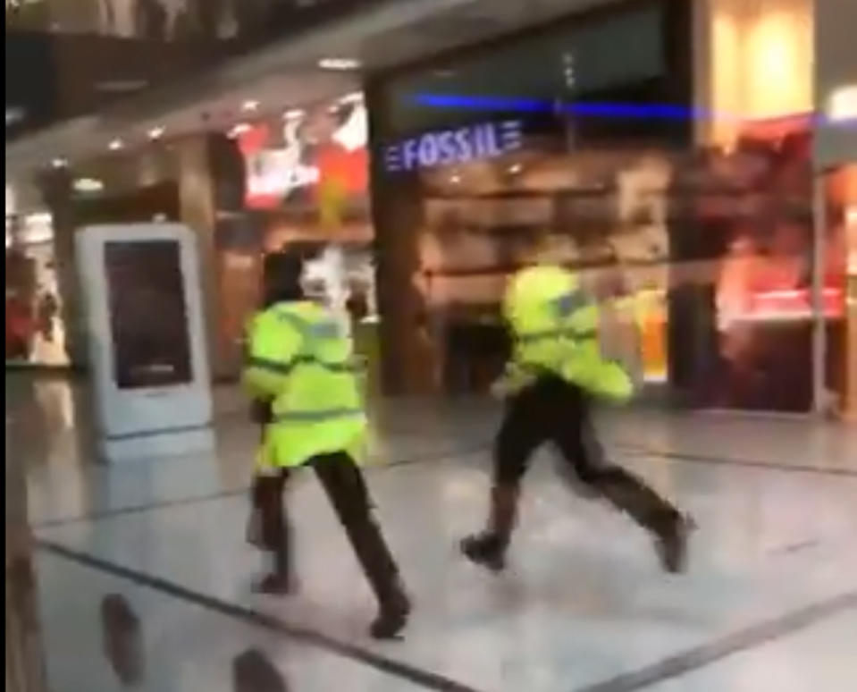 Police run through the Arndale Centre in Manchester in response to a stabbing incident (PA/TWITTER@GrizzleMarine)