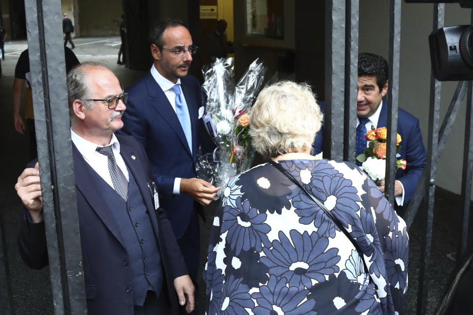 Alvaro Domingo, right, son of singer Placido Domingo, receives flowers of his father's fans at the 'Festspielhaus' opera house where Placido Domingo will perform 'Luisa Miller' by Giuseppe Verdi in Salzburg, Austria, Sunday, Aug. 25, 2019. Domingo is scheduled to appear onstage at the Salzburg Festival to perform for the first time since multiple women have accused the opera legend of sexual harassment in allegations brought to light by The Associated Press. (AP Photo/Matthias Schrader)