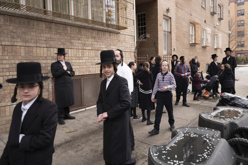 Jewish men and children gather on a sidewalk, Wednesday, April 8, 2020 on the first day of Passover in the Williamsburg neighborhood of New York during the coronavirus pandemic. (AP Photo/Mark Lennihan)