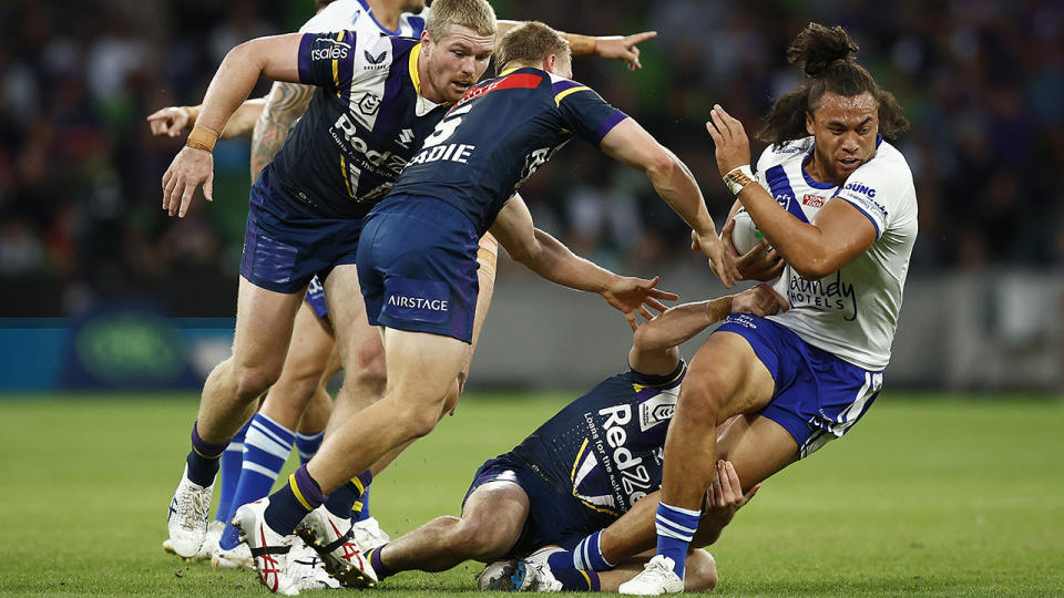 Raymond Faitala-Mariner attempts to evade Melbourne Storm defenders.