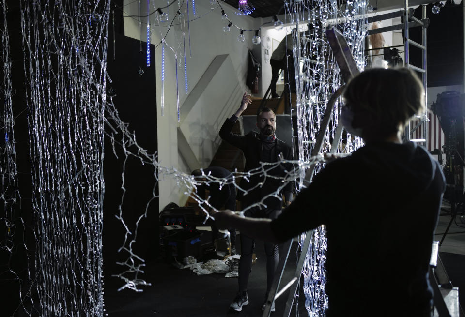 El diseñador francés Julien Fournie, al fondo, da instrucciones durante una filmación para la presentación digital de su colección primavera-verano 2021 en la Semana de la Moda de París, el jueves 7 de enero del 2021 en la capital francesa. (AP Foto/Francois Mori)