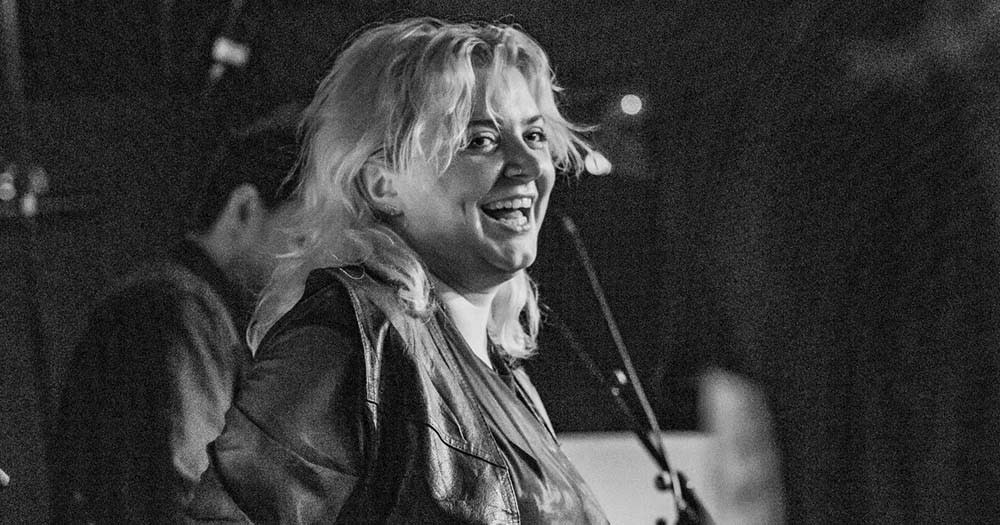 Black and white photo of SPRINTS singer Karla Chubb singing into a microphone