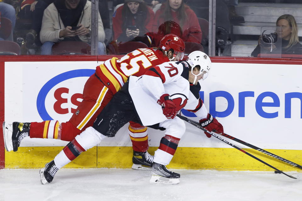 New Jersey Devils' Jesper Boqvist, right, vies for the puck against Calgary Flames' Noah Hanifin during the second period of an NHL hockey game Saturday, Nov. 5, 2022, in Calgary, Alberta. (Larry MacDougal/The Canadian Press via AP)