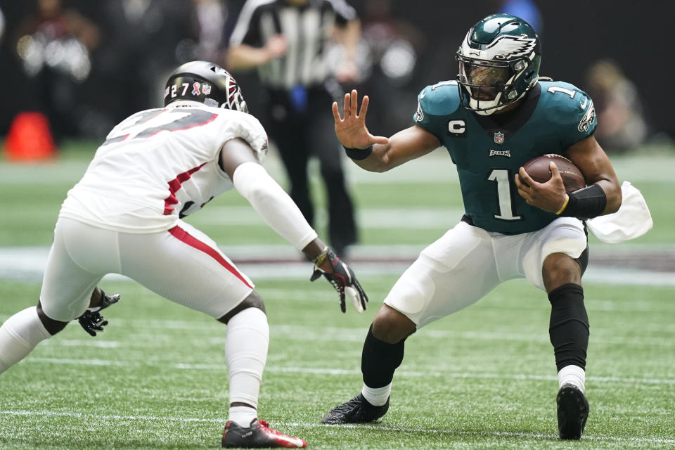 Philadelphia Eagles quarterback Jalen Hurts (1) runs near Atlanta Falcons safety Richie Grant (27) during the second half of an NFL football game, Sunday, Sept. 12, 2021, in Atlanta. (AP Photo/Brynn Anderson)