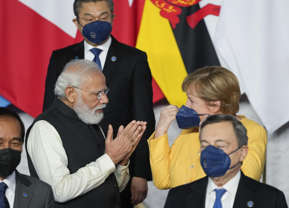 India's Prime Minister Narendra Modi, left, and German Chancellor Angela Merkel talk prior to a group photo of world leaders at the La Nuvola conference center for the G20 summit in Rome, Saturday, Oct. 30, 2021. The two-day Group of 20 summit is the first in-person gathering of leaders of the world's biggest economies since the COVID-19 pandemic started. (AP Photo/Gregorio Borgia)